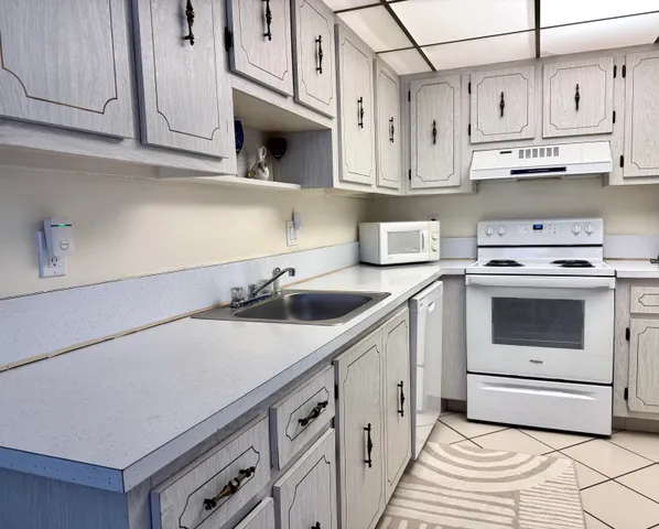 a kitchen with stainless steel appliances granite countertop a sink a stove and cabinets