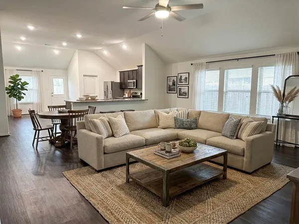 a living room with furniture a wooden floor and a chandelier
