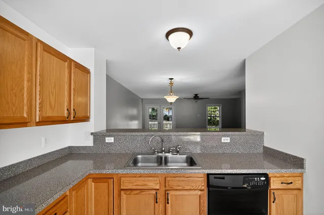 a kitchen with granite countertop a sink stainless steel appliances and cabinets