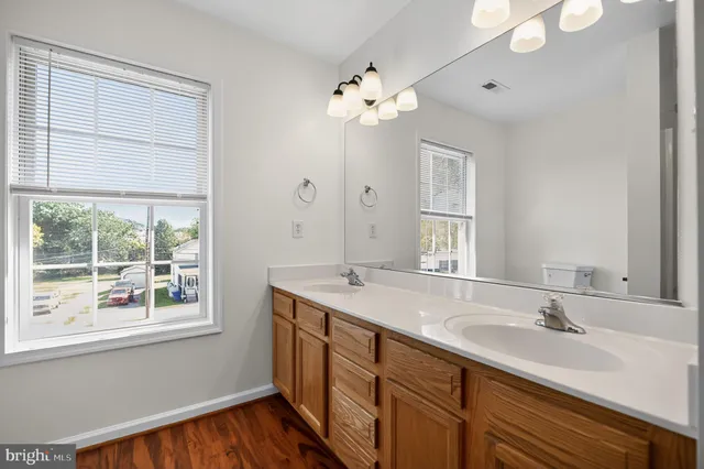 a bathroom with a granite countertop sink a large mirror a and a window