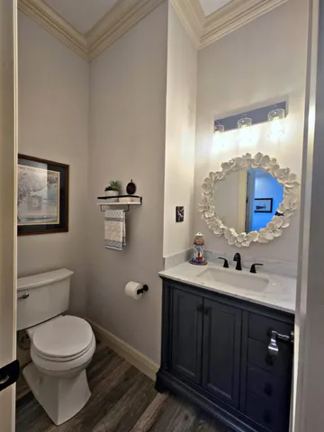 a bathroom with a toilet a sink a mirror and vanity