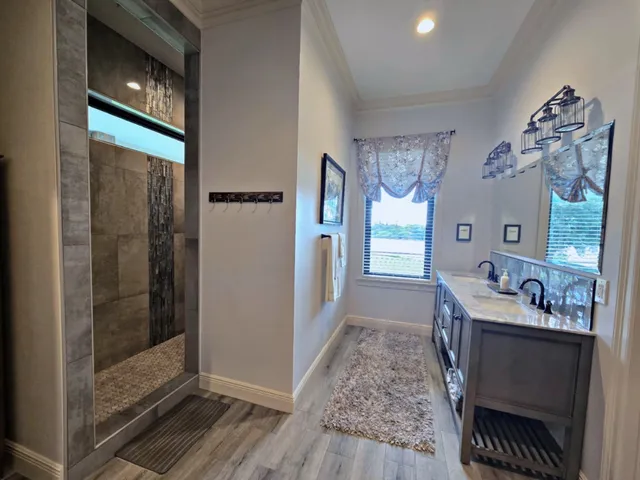 a spacious bathroom with a granite countertop sink a mirror and shower