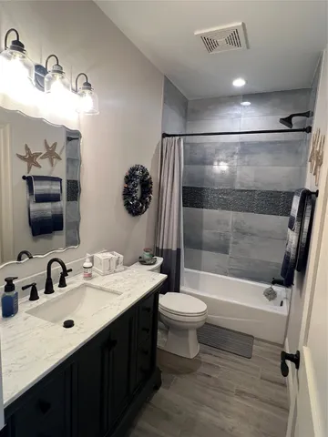 a bathroom with a sink toilet a mirror and shower