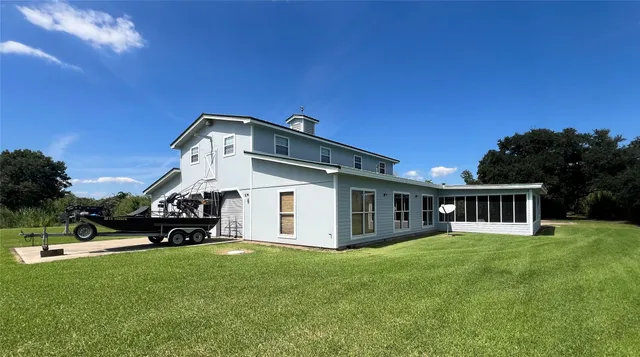 a view of a house with a big yard and large trees