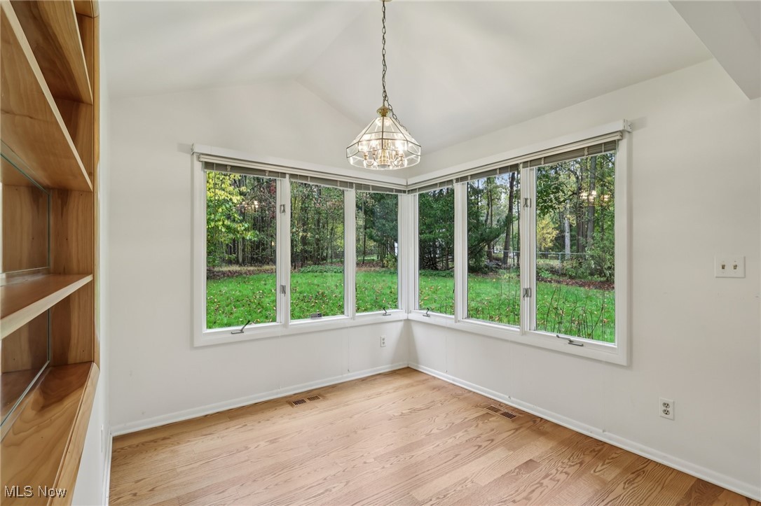 33300 South Woodland Road Cleveland, OH 44124 - Photo 18 of 50 Unfurnished dining area with light wood finished floors, a chandelier, and lofted ceiling