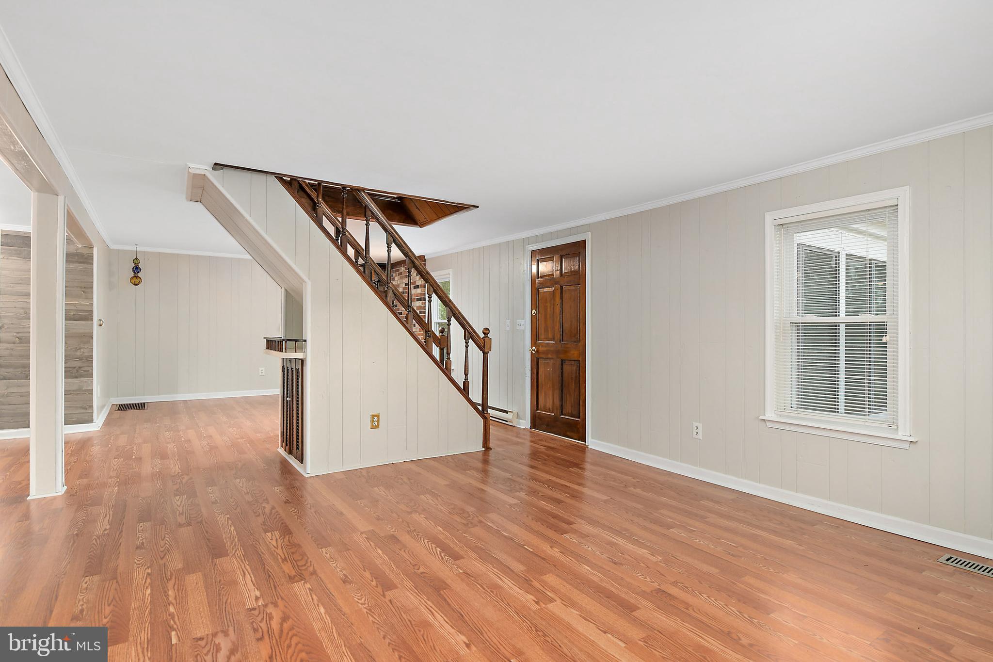 10826 Brownstone Road Princess Anne, MD 21853 - Photo 20 of 68 a view of an empty room with wooden floor and stairs