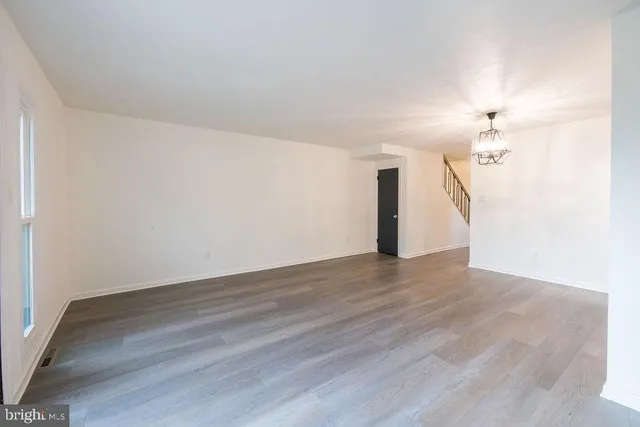 a view of a livingroom with wooden floor and a ceiling fan