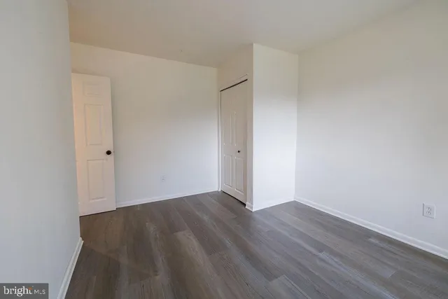 a view of a room with wooden floor and a window