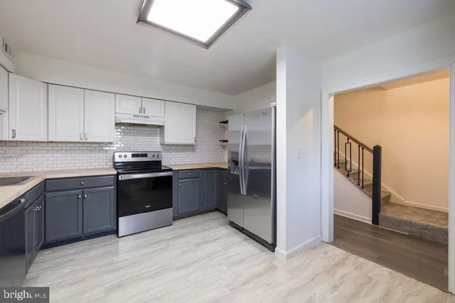 a kitchen with stainless steel appliances granite countertop a refrigerator and a stove top oven