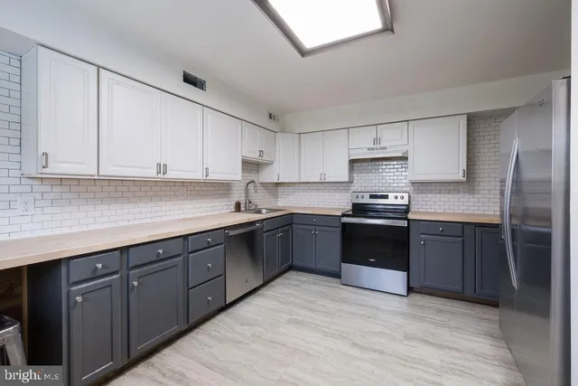 a kitchen with stainless steel appliances granite countertop a stove sink and cabinets