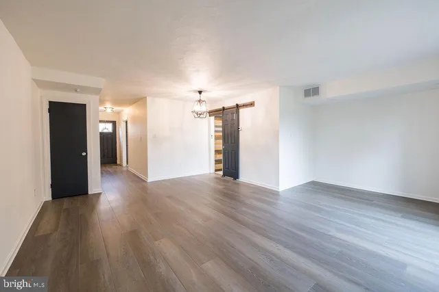a view of a big room with wooden floor and windows