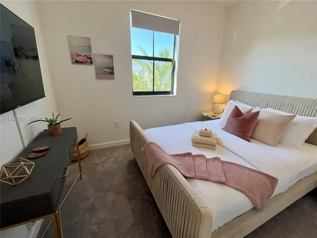 a bedroom with a bed and a potted plant