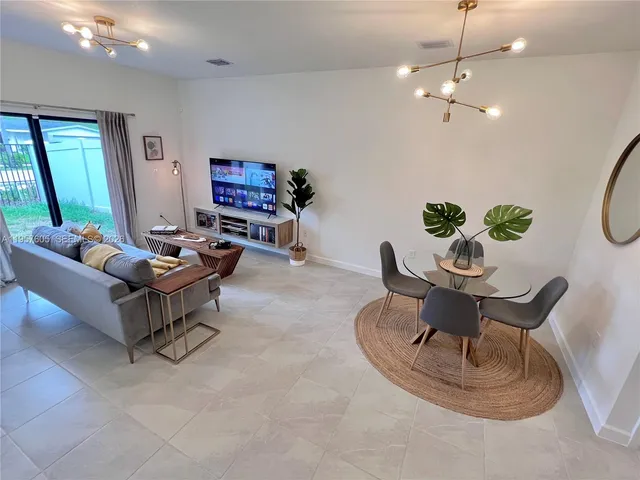 a living room with furniture and a chandelier