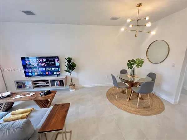 a living room with furniture a dining table and a chandelier