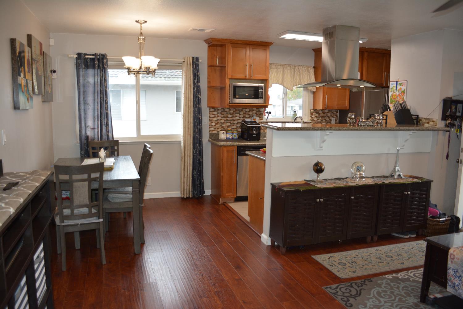 5630 Allen Avenue, Unit 4 San Jose, CA 95123 - Photo 19 of 23 a kitchen with stainless steel appliances kitchen island granite countertop a refrigerator a stove top oven and a dining table with wooden floor