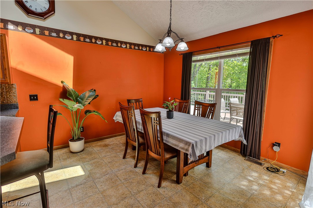 11154 Johnsford Road Southwest Beach City, OH 44608 - Photo 24 of 50 Spacious dining area featuring vaulted ceilings, tile flooring, and a multi-light chandelier
