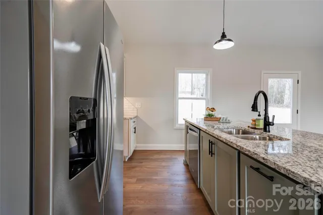 a kitchen with stainless steel appliances granite countertop a sink and a refrigerator