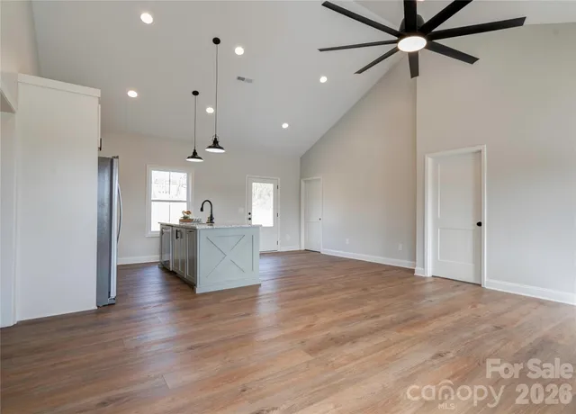 a view of an empty room and kitchen view
