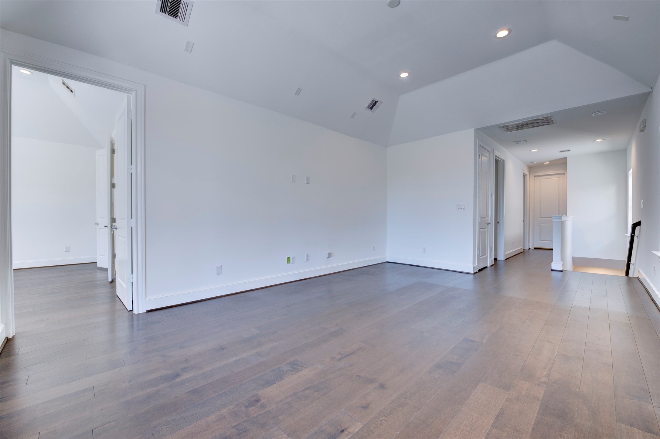 4947 Rusk Street Houston, TX 77023 - Photo 14 of 40 Second floor living area with view to primary bedroom at left and secondary bedrooms and utility room down the hall at right.