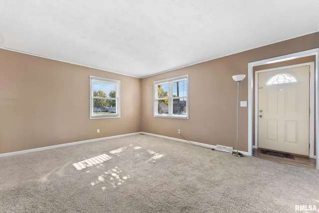 an empty room with windows and closet