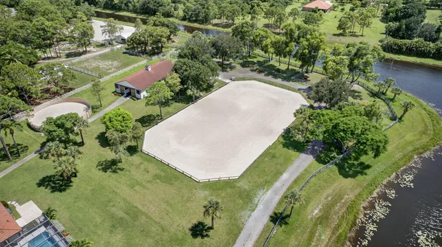an aerial view of a residential houses with outdoor space and trees