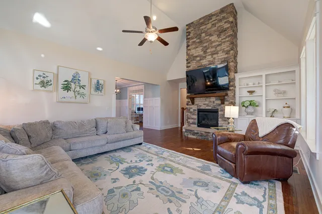 a living room with furniture a flat screen tv and a fireplace