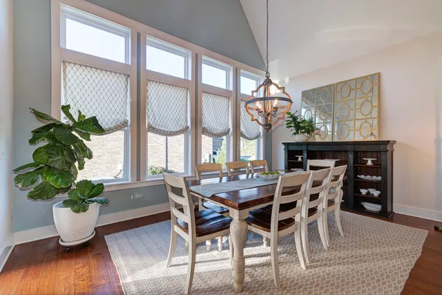 a dining room with furniture potted plants and wooden floor