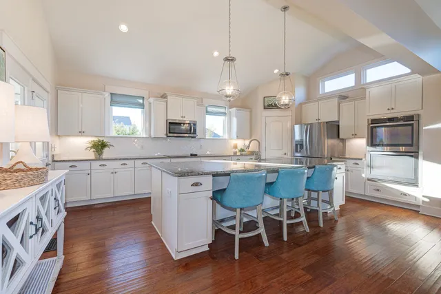 a kitchen with stainless steel appliances a dining table chairs stove and refrigerator