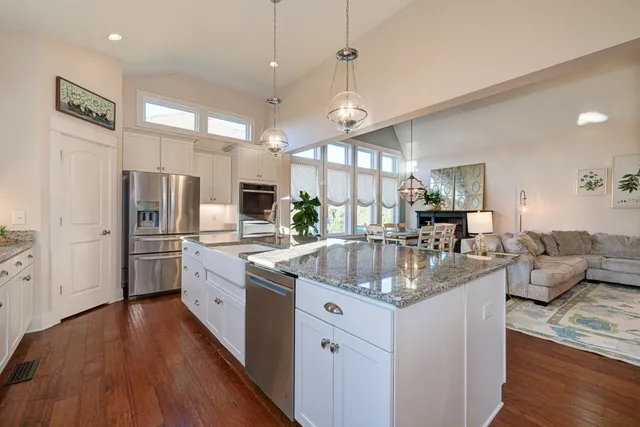 a kitchen with stainless steel appliances granite countertop a lot of counter space and wooden floors
