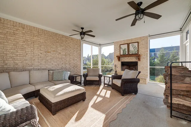 a living room with furniture a fireplace and a floor to ceiling window