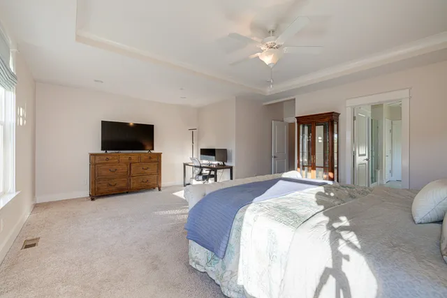 a spacious bedroom with a bed and a flat screen tv