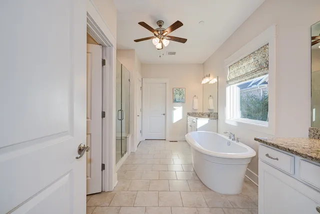 a spacious bathroom with a double vanity sink a mirror and a bathtub