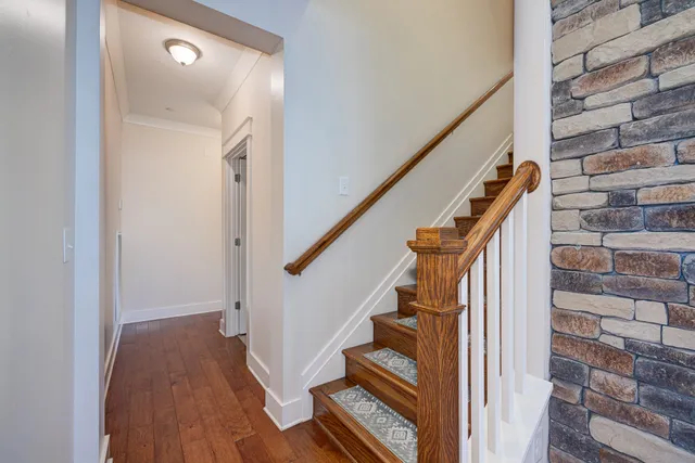 a view of staircase with wooden floor and white walls