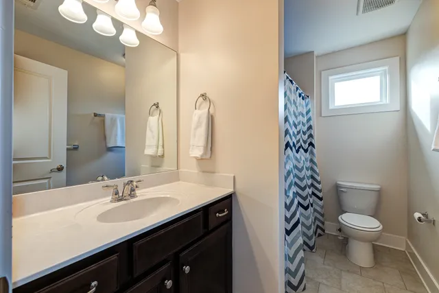 a bathroom with a sink a toilet a mirror and shower