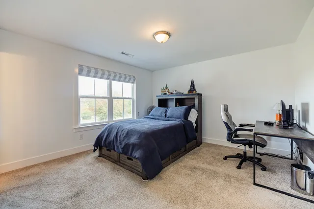 a spacious bedroom with a bed and a desk