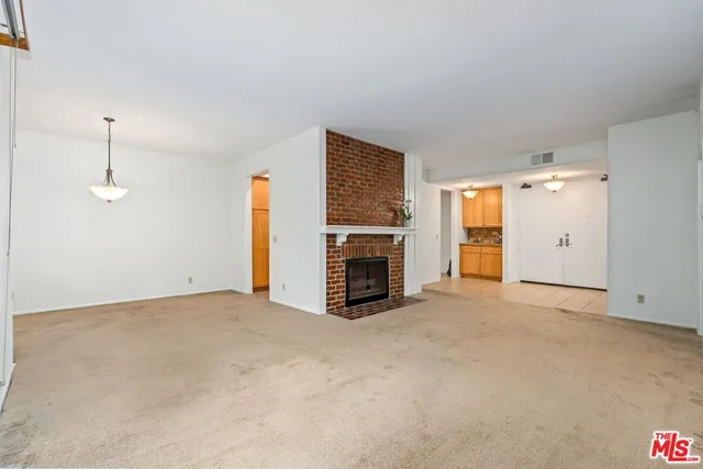 an empty room with fireplace and windows