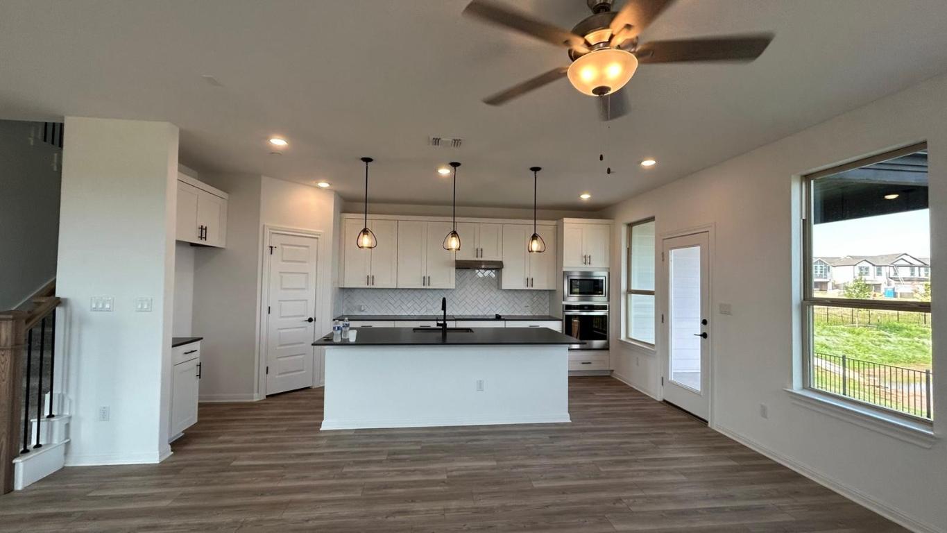 2725 Woodall Drive, Unit 204 Cedar Park, TX 78613 - Photo 1 of 14 Kitchen featuring dark countertops, an island with sink, dark wood-style floors, stainless steel appliances, and recessed lighting