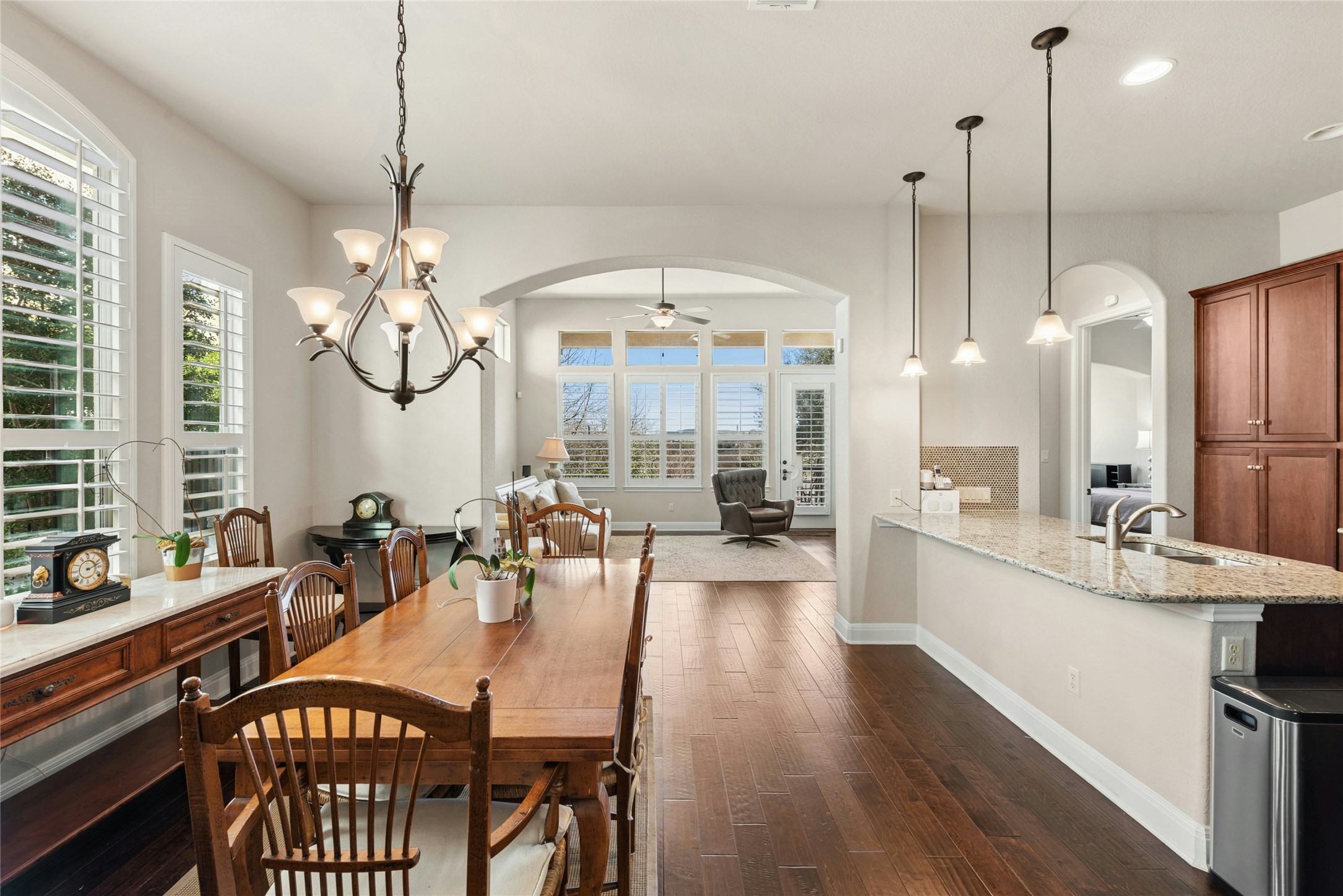116 Evolutions Path Lakeway, TX 78738 - Photo 8 of 34 Dining area featuring a ceiling fan, arched walkways, dark wood finished floors, and hanging lights