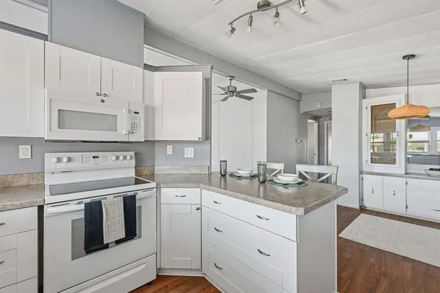 a kitchen with white cabinets and white appliances