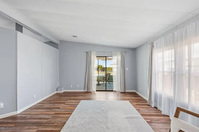 a view of a room with wooden floor and windows