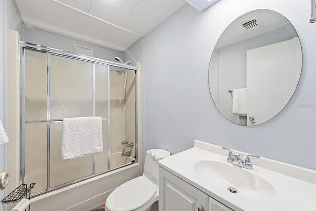 a view of a bedroom with wooden floor and white walls