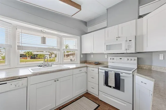 a kitchen with white cabinets sink and white appliances