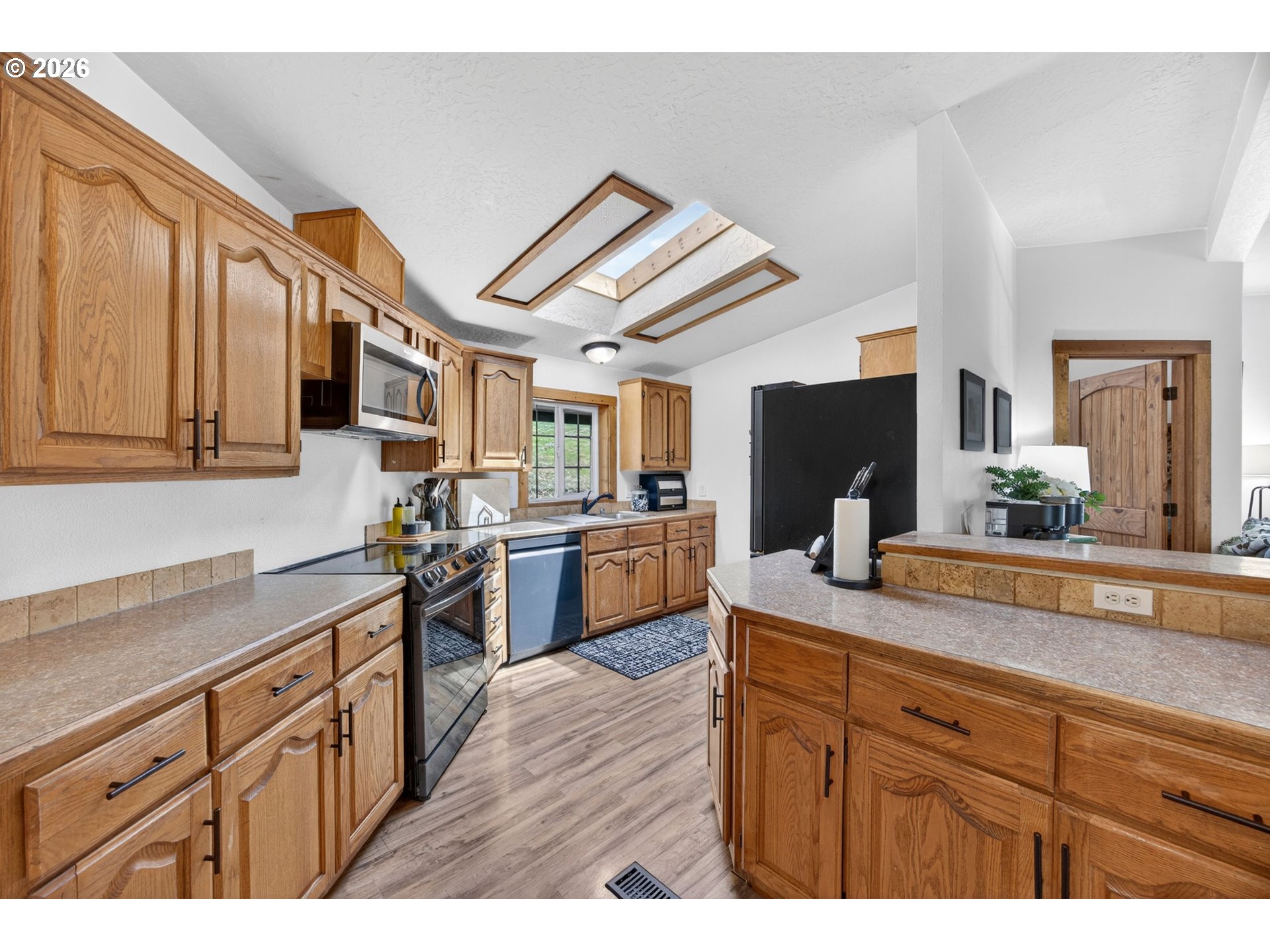 6895 Canary Road Westlake, OR 97493 - Photo 6 of 40 a kitchen with stainless steel appliances kitchen island granite countertop a sink and cabinets
