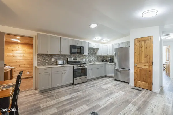 a kitchen with a refrigerator and a stove top oven