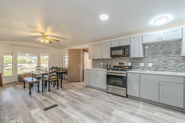 a kitchen with a dining table chairs and white appliances
