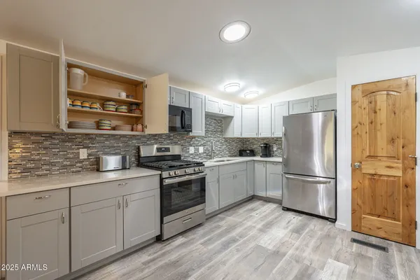 a kitchen with a refrigerator stove top oven and sink