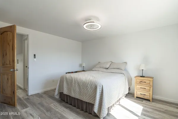 a bedroom with a bed and wooden floor