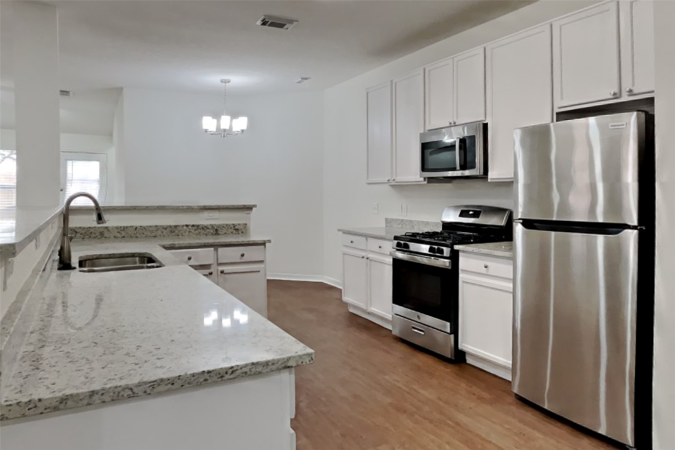 10414 Falling River Drive Houston, TX 77095 - Photo 3 of 18 a kitchen with stainless steel appliances granite countertop a refrigerator a stove a sink and white cabinets