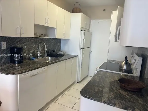 a kitchen with stainless steel appliances granite countertop a sink a stove and a refrigerator