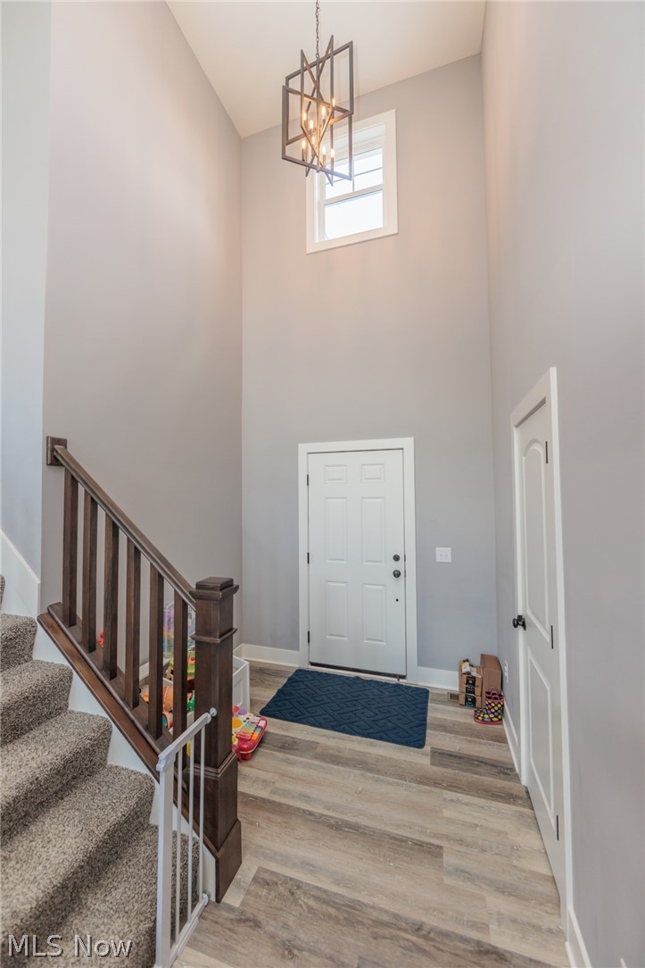 Foyer entrance featuring a high ceiling, a chandelier, and hardwood / wood-style floors